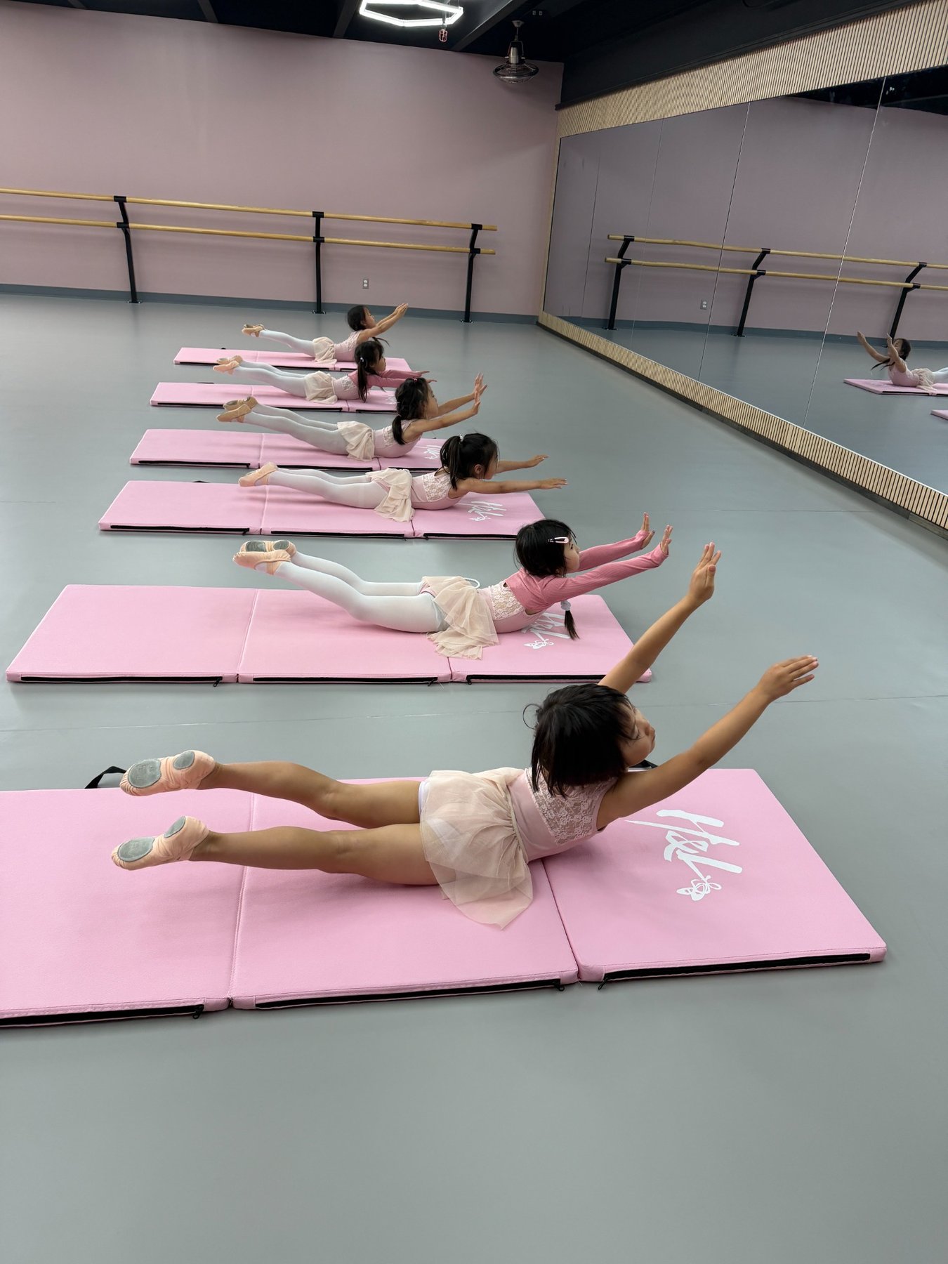 Chinese dance student practicing with a traditional umbrella prop in the new studio